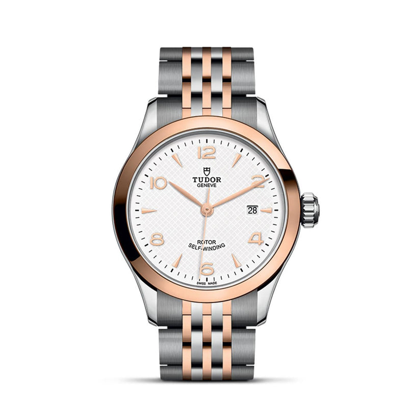The TUDOR 1926 wristwatch features a white textured dial, gold hour markers, a date window at 3 o’clock, and a rose gold and silver bracelet—ideal for those who value elegant timepieces.