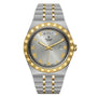 The TUDOR Royal is a wristwatch featuring a silver and gold band, gold Roman numerals, day display at 12 o’clock, date window at 3 o’clock on a silver dial, and timeless design inspired by Rolex.
