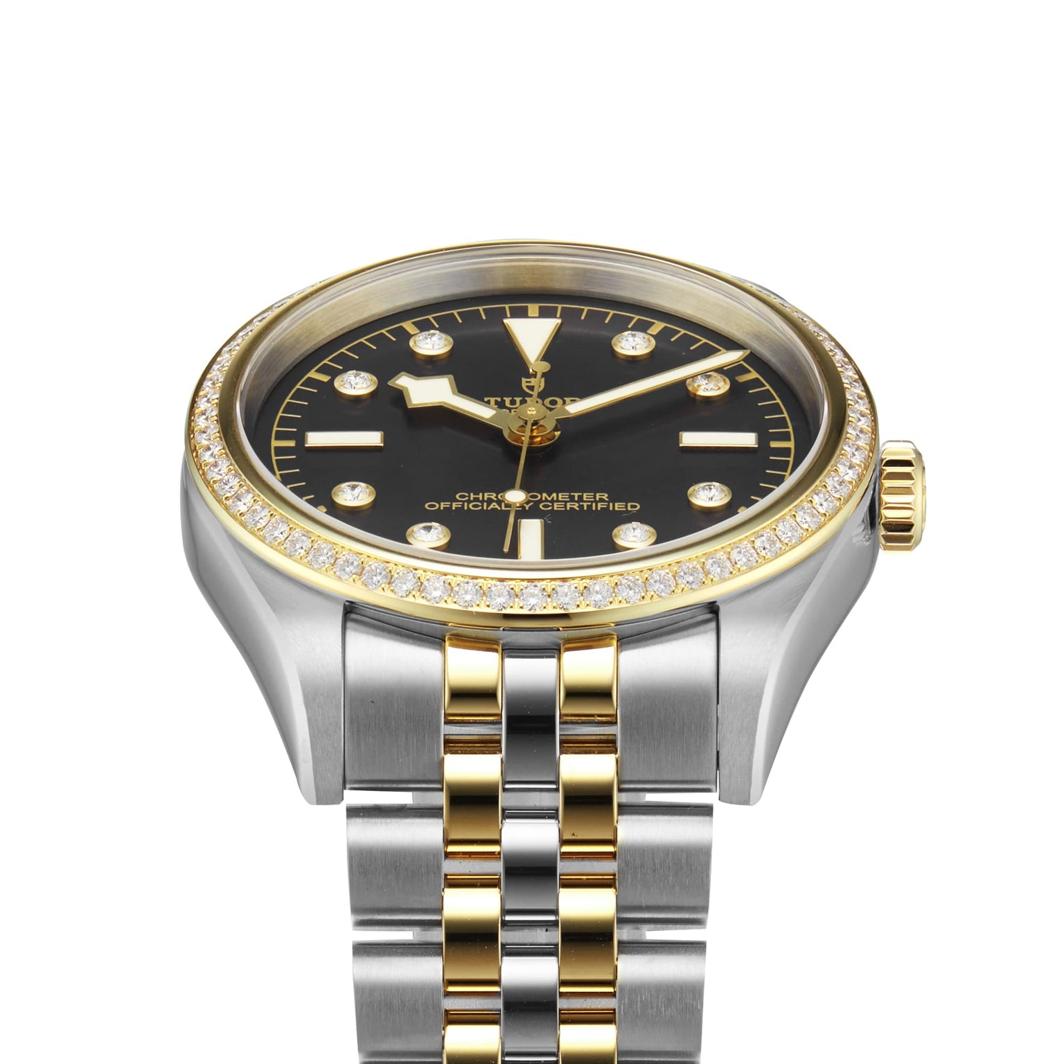 The TUDOR Black Bay One 36 S&G features a black dial with yellow gold markers, a diamond bezel, and a stainless steel and gold bracelet, displayed on a white background.