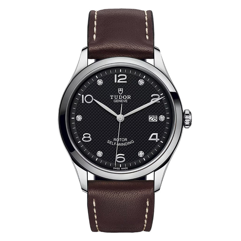 The TUDOR 1926 wristwatch features a black textured dial, silver hour markers, a date window at 3 o’clock, and a brown leather strap with white stitching—reflecting the classic craftsmanship of TUDOR.
