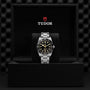 A TUDOR Black Bay 54 dive watch with a black dial and stainless steel band is displayed upright in a black, Tudor-branded presentation box.