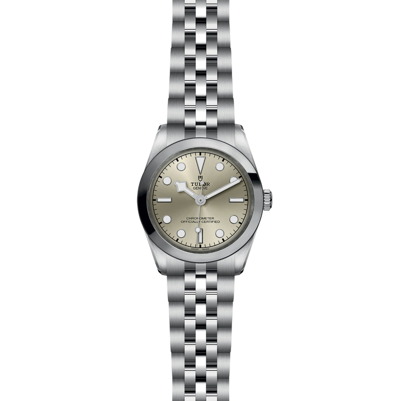 A TUDOR Black Bay One 31 wristwatch with a metal link bracelet and a light-colored dial.