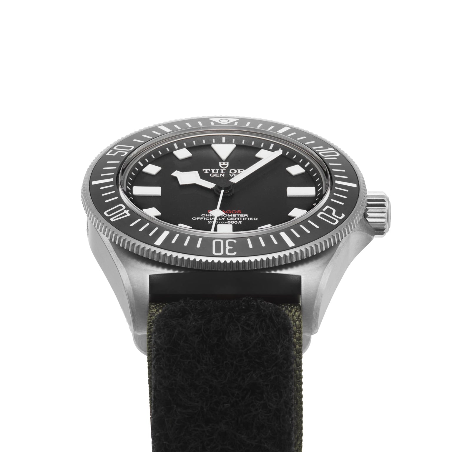 A close-up of the TUDOR Pelagos FXD diving watch, featuring a black dial, bold white hour markers, rotating bezel, and a black fabric strap—showcasing its robust design.