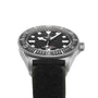 A close-up of the TUDOR Pelagos FXD diving watch, featuring a black dial, bold white hour markers, rotating bezel, and a black fabric strap—showcasing its robust design.