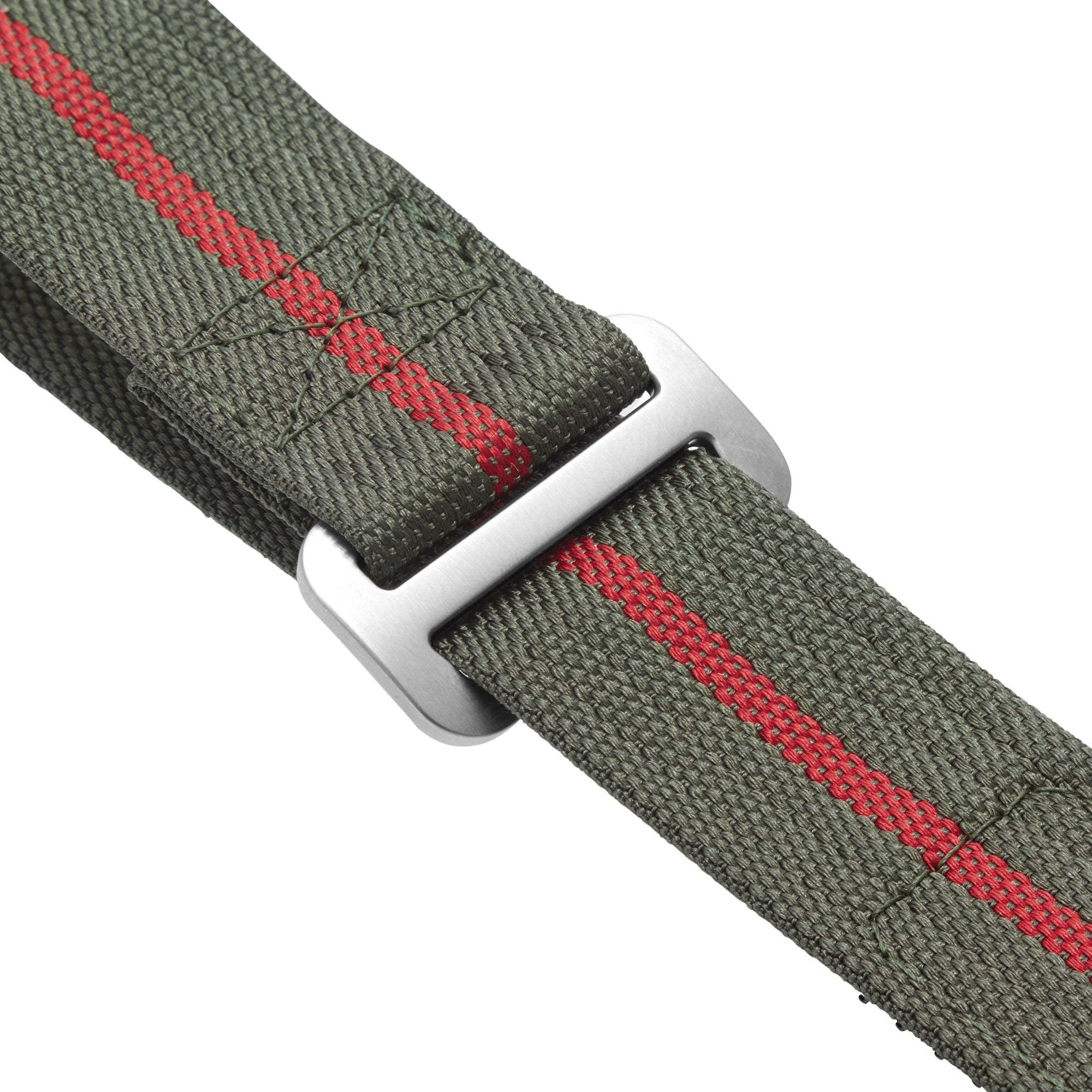 Close-up of a green fabric strap with a red stripe and silver rectangular buckle, inspired by those found on the TUDOR Pelagos FXD diving watch.