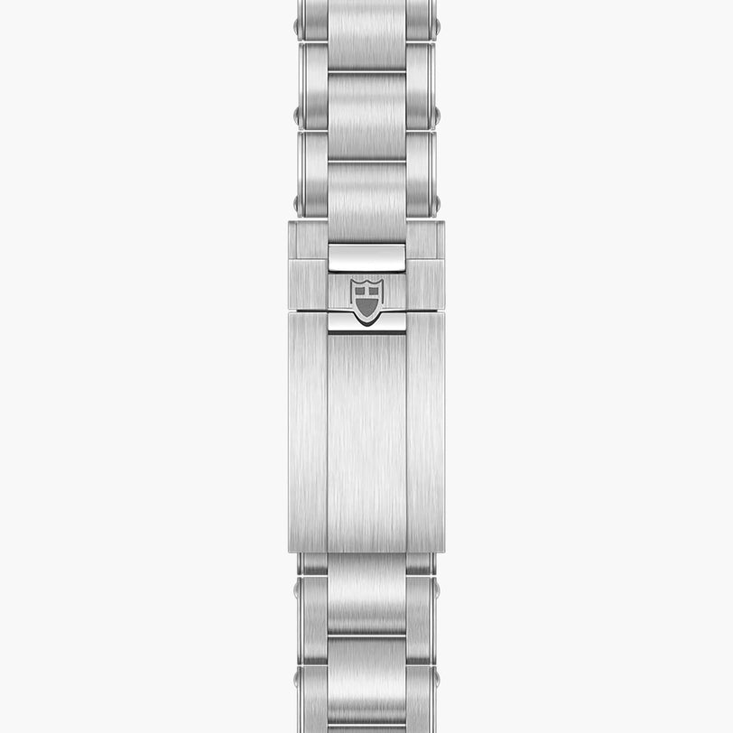 The TUDOR Black Bay 58 features a silver metal watch bracelet with a clasp showcasing an engraved shield logo at the center.