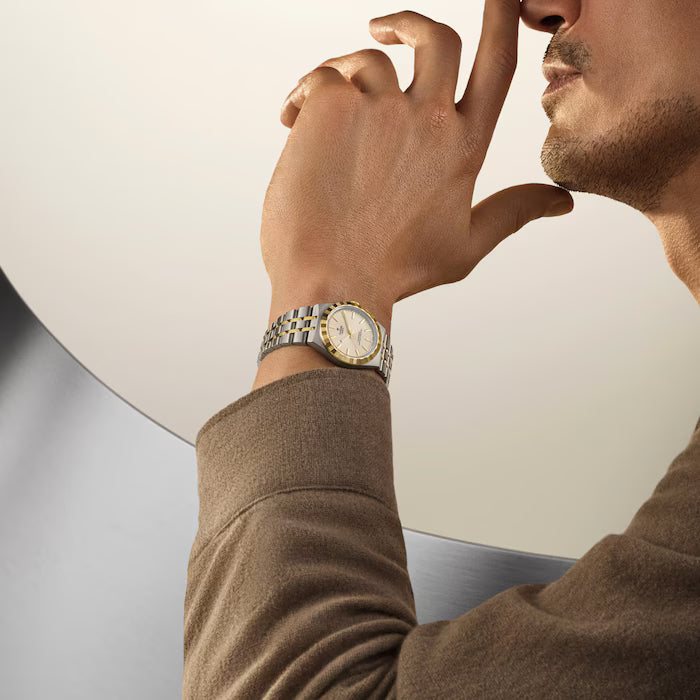 Man wearing TUDOR Royal watch with two-tone steel bracelet and champagne dial on wrist.