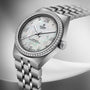 TUDOR Royal stainless steel watch with mother-of-pearl dial, diamond bezel, and two-tone bracelet.