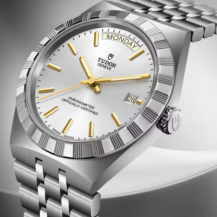 Tudor Royal stainless steel watch with silver dial, gold hour markers and hands, day-date window, and matching bracelet.