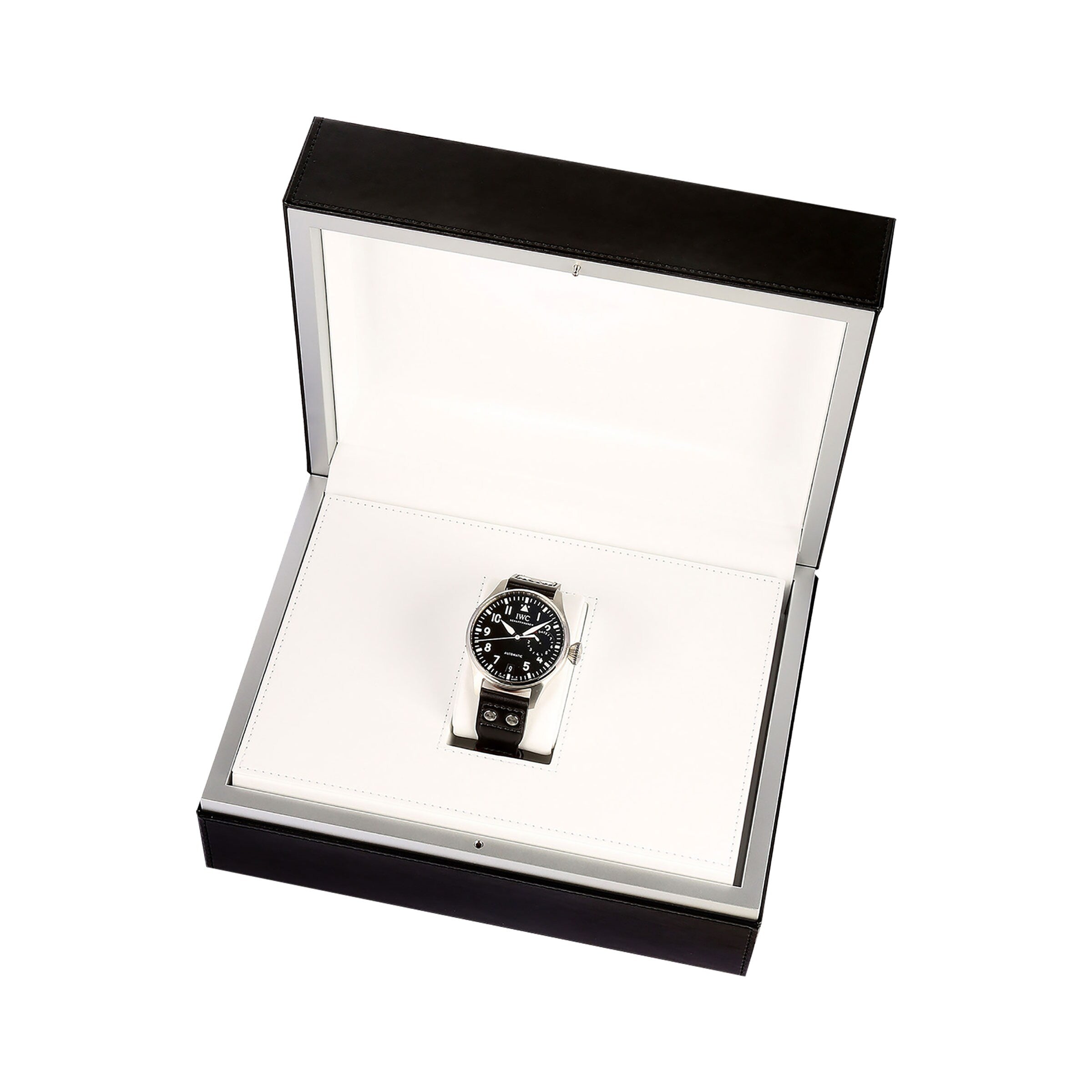 The IWC Schaffhausen Big Pilots Watch features a black dial and metal band, elegantly presented in an open black and white box against a white background.