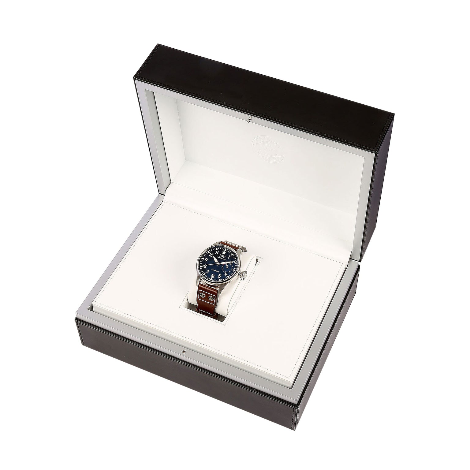 The IWC Schaffhausen Big Pilots Watch Edition Le Petit Prince, featuring a brown leather strap, dark dial, and stainless steel case, is displayed in an open black and white presentation box.