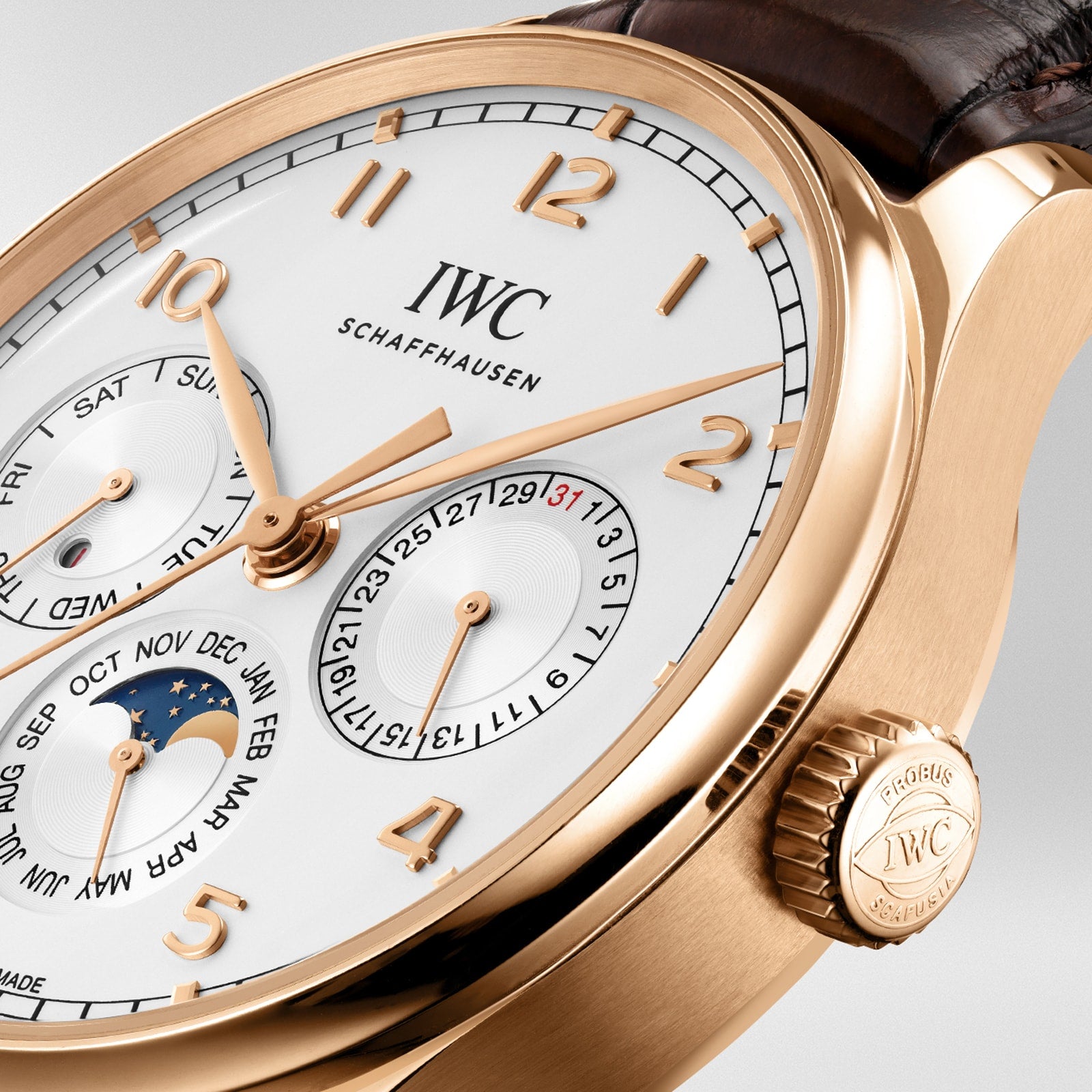Close-up of the IWC Schaffhausen Portugieser Perpetual Calendar 42 wristwatch, featuring an 18ct gold case, white dial, leather strap, and subdials displaying perpetual calendar and moon phase complications.