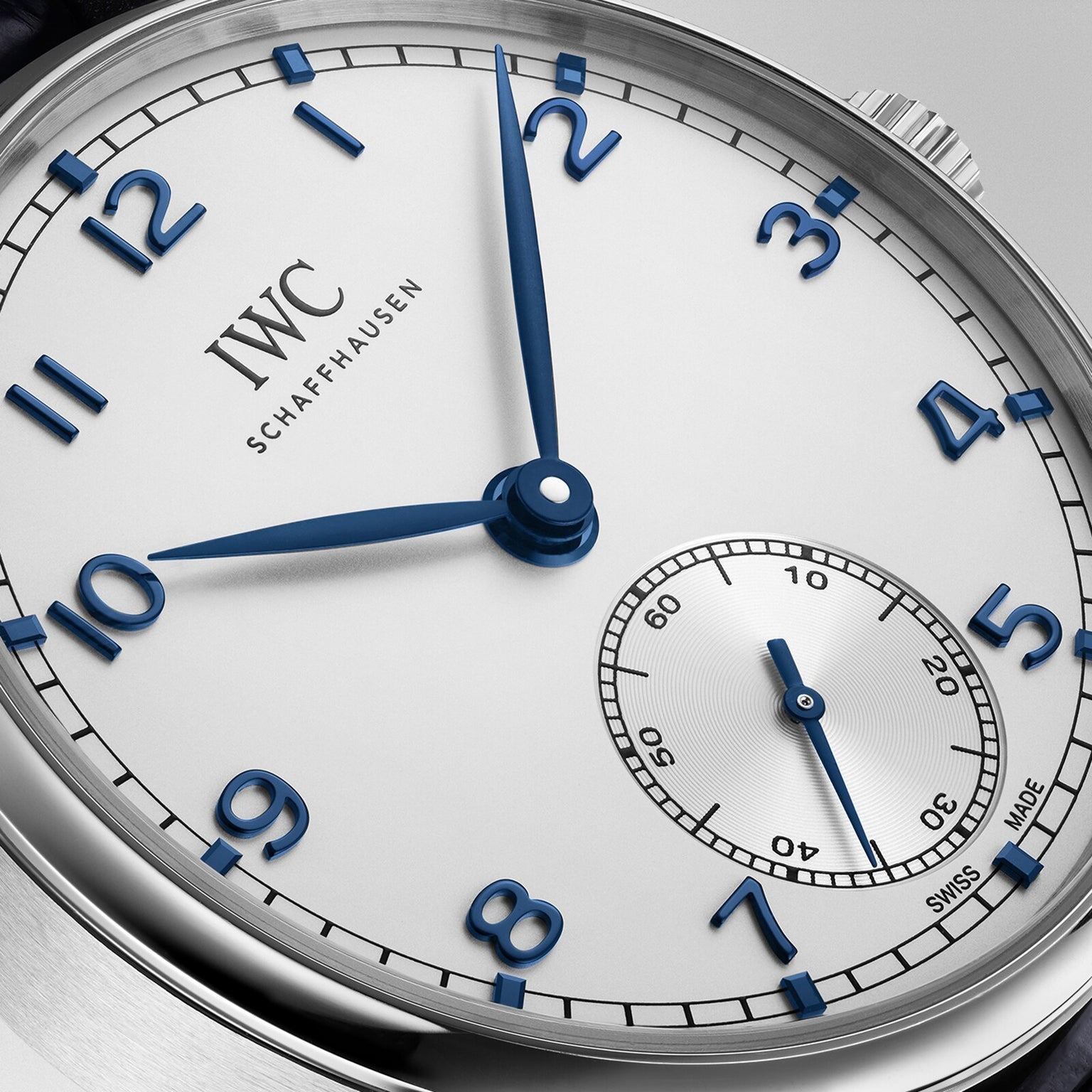 Close-up of an IWC Schaffhausen Portugieser Automatic 40 wristwatch featuring a white dial, blue hands and numerals, and a small seconds subdial at the 6 o’clock position.