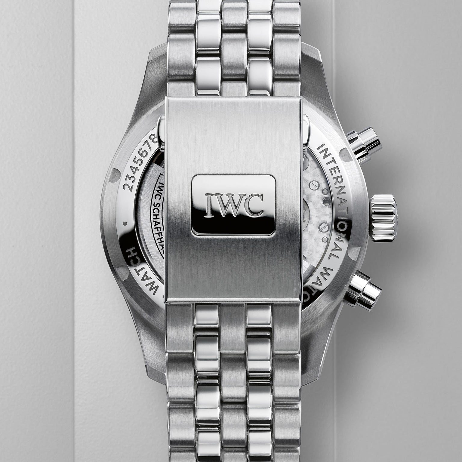 Close-up of the back of an IWC Schaffhausen Pilots Watch Chronograph 41, highlighting its stainless steel bracelet, clasp with engraved IWC logo, and a glimpse of the watch’s mechanical movement from the iconic collection.
