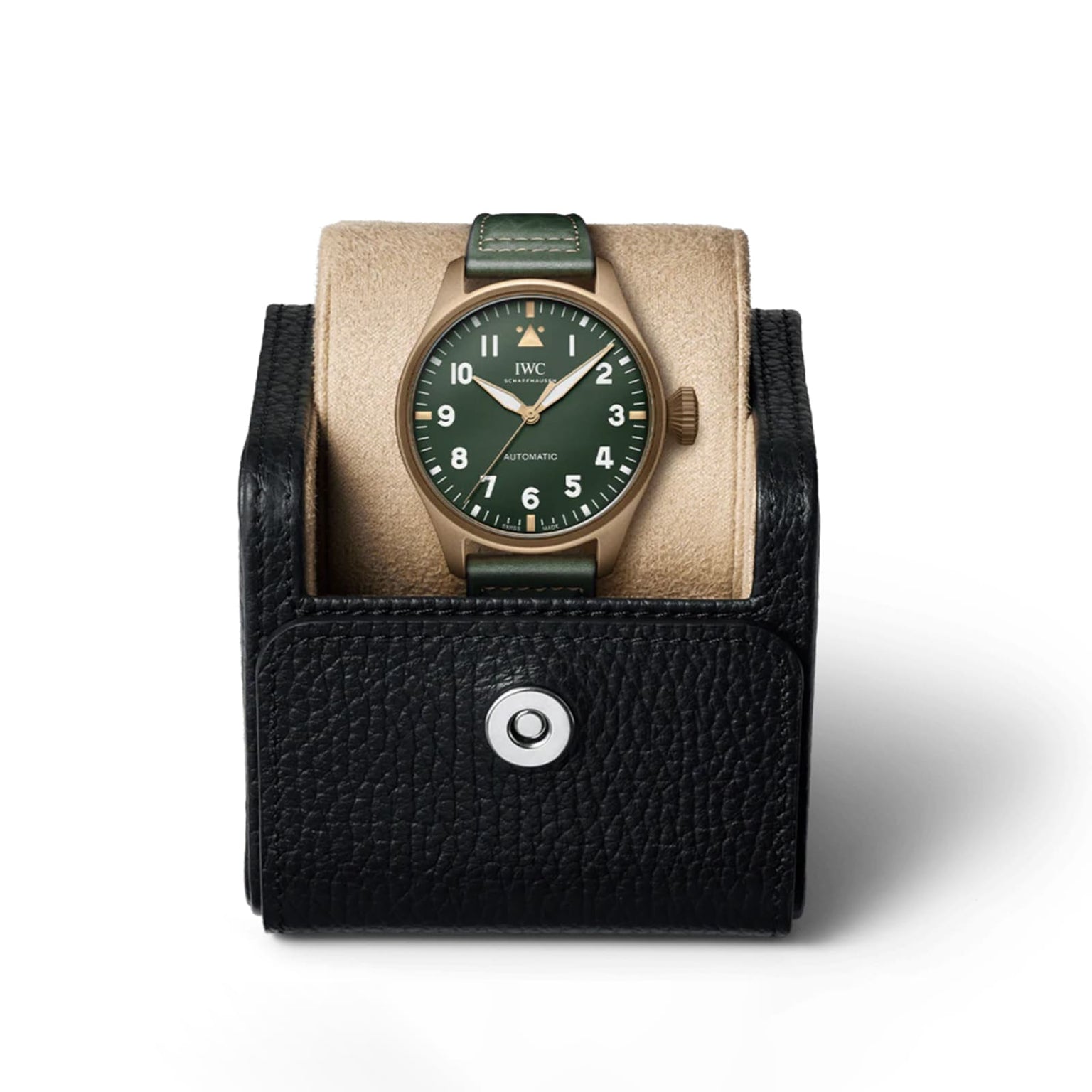 The IWC Schaffhausen Big Pilots Watch 43 Spitfire, featuring a green dial and leather strap, is displayed upright in a black textured watch case with a button closure.