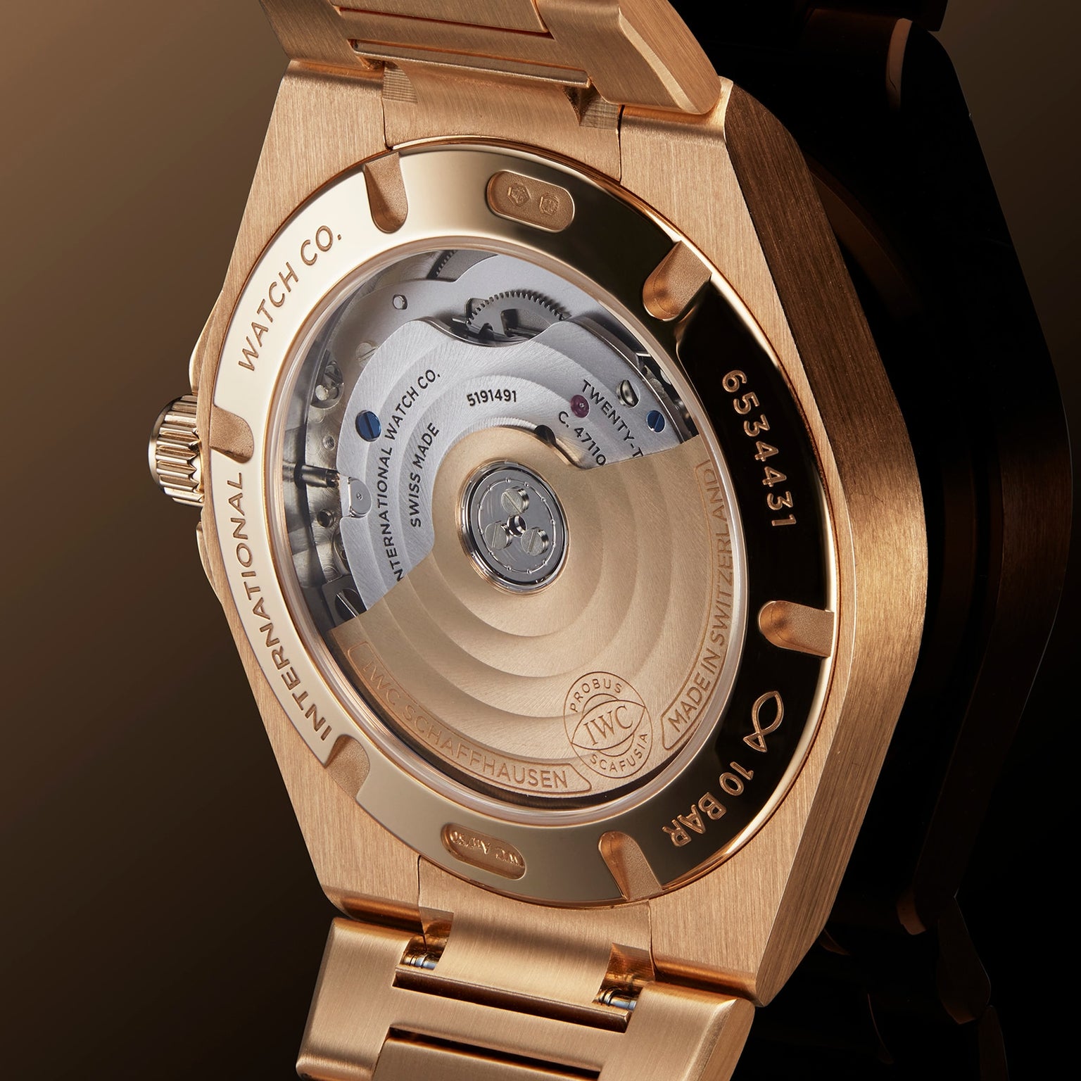 Close-up of the IWC Schaffhausen Ingenieur Automatic 35’s back, showcasing its open mechanical movement and detailed engravings on the gold case—an homage to Gérald Genta’s legendary design.