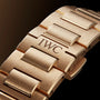 Close-up of the Ingenieur Automatic 40s 18-carat gold bracelet by IWC Schaffhausen, featuring an engraved link, set against a dark background.