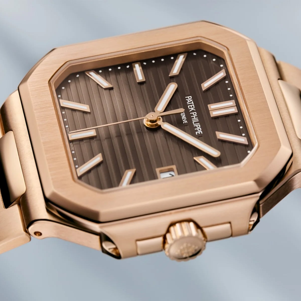 Close-up of the Patek Philippe Cubitus 7128/1R-001, featuring a gold case, brown striped dial, and geometric bezel.