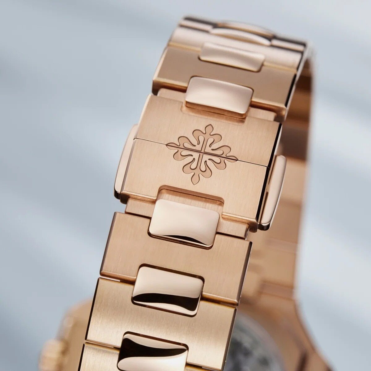 Close-up of the Patek Philippe Cubitus 7128/1R-001 gold bracelet, highlighting the engraved logo on its clasp.