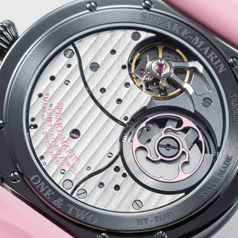 Close-up of the Speake Marin Dual Time Pink watch movement, showcasing its intricate gears, screws, and detailed metal engravings.