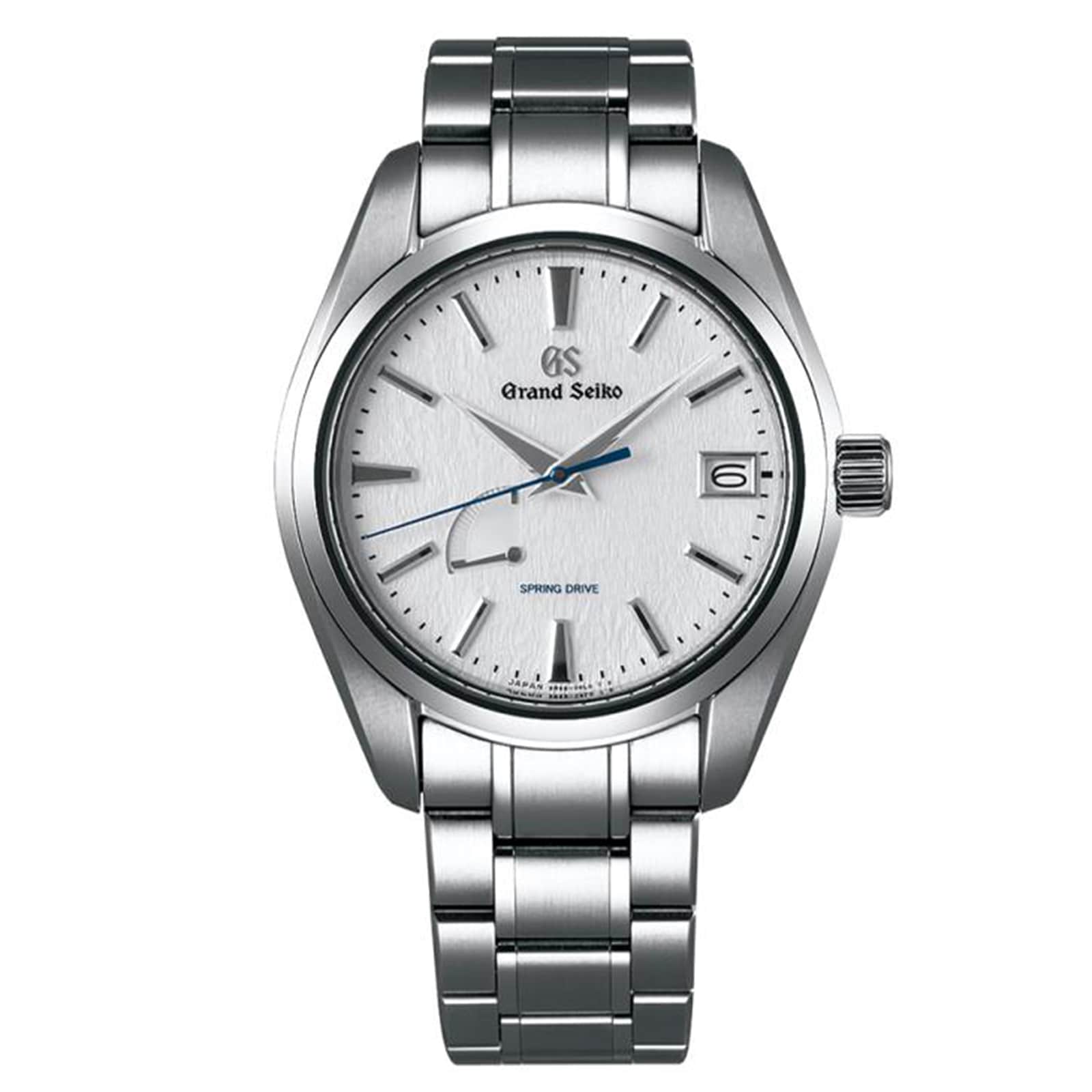 The Grand Seiko Spring Drive Heritage features a white textured dial, silver tone markers and hands, a blue seconds hand, date at 3 o’clock, and precise Spring Drive movement in a stainless steel case.