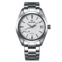 The Grand Seiko Spring Drive Heritage features a white textured dial, silver tone markers and hands, a blue seconds hand, date at 3 o’clock, and precise Spring Drive movement in a stainless steel case.