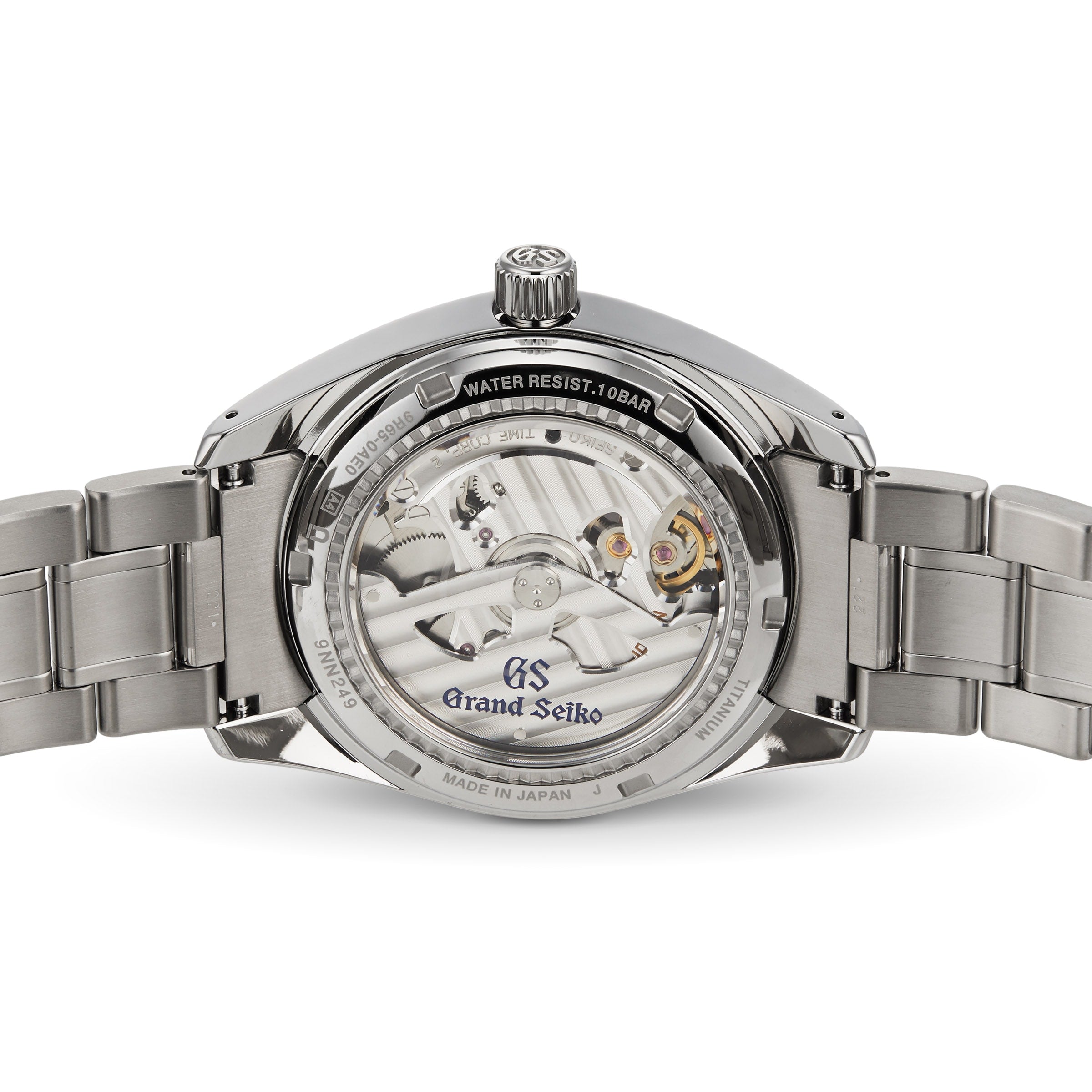 Rear view of the Grand Seiko Spring Drive Heritage, featuring its open caseback that reveals the Spring Drive movement and engraved branding, with a titanium case and stainless steel bracelet.