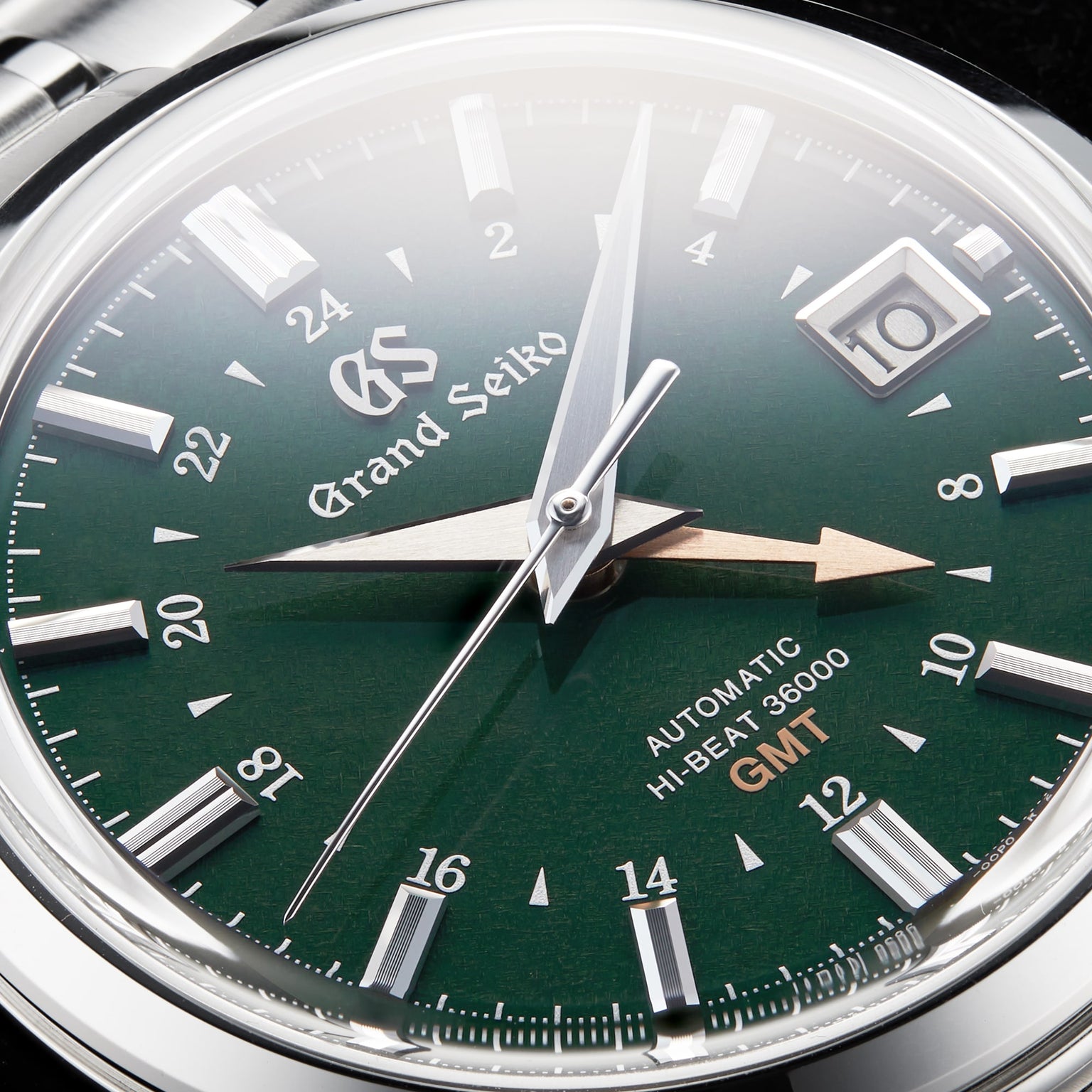 Close-up of the Grand Seiko Hi-Beat GMT Elegance watch, featuring a green dial, time, date window, and Automatic Hi-Beat 36000 GMT with Calibre 9S86 movement.
