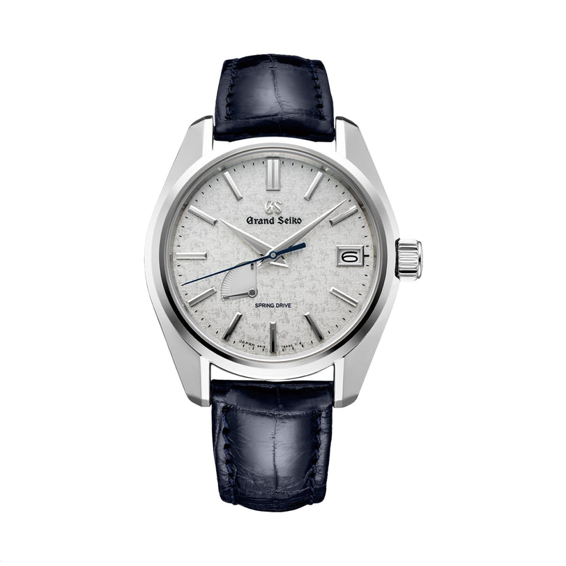 The Grand Seiko Spring Drive Heritage features a textured silver dial, blue second hand, date window, and black leather strap.