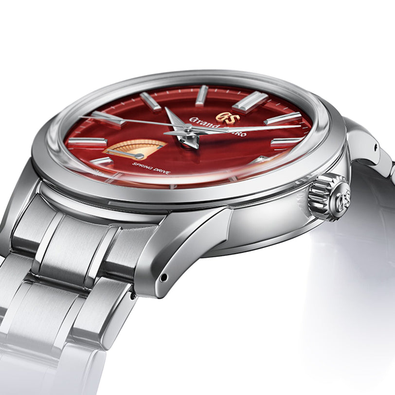 A close-up shows the Grand Seiko Spring Drive Elegance, a limited edition wristwatch featuring a red dial, silver hour markers, and a silver stainless steel bracelet.