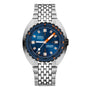 The DOXA Sub 300 Beta Caribbean is a silver wristwatch with a blue dial, ceramic bezel, silver hour markers, orange minute hand, date window at 3 oclock, and metal bracelet—an iconic water-resistant sports watch.