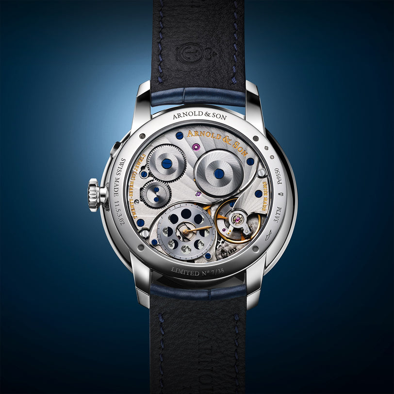 The back of the Arnold & Son Perpetual Moon 41.5mm Platinum watch displays exposed gears and intricate mechanical details.