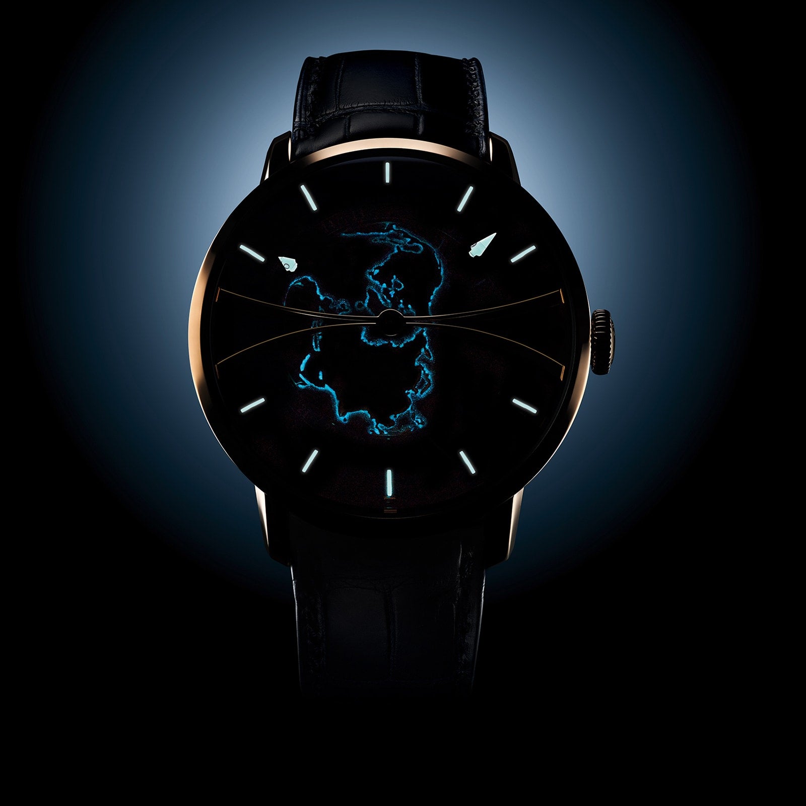 The Arnold & Son Globetrotter Red Gold features a dark dial with a luminous blue outline of Antarctica and minimal hour markers.