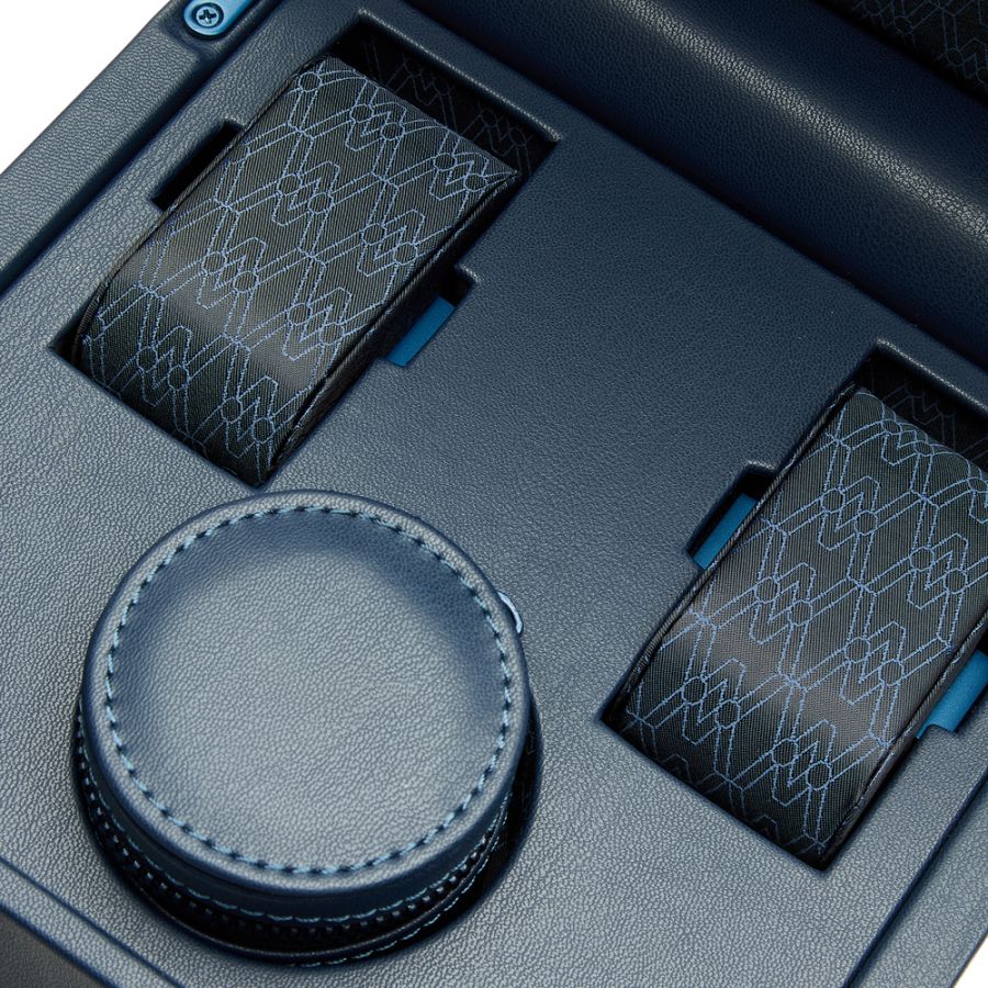 Blue leather watch winder with circular rotating pad and two patterned watch pillows, front view.