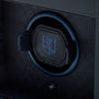 Black watch winder with blue trim and embroidered crest on cushioned watch bed.