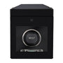 A black WOLF British Racing Single Watch Winder with storage, featuring a dial, digital display, and a keyhole above the front lock.