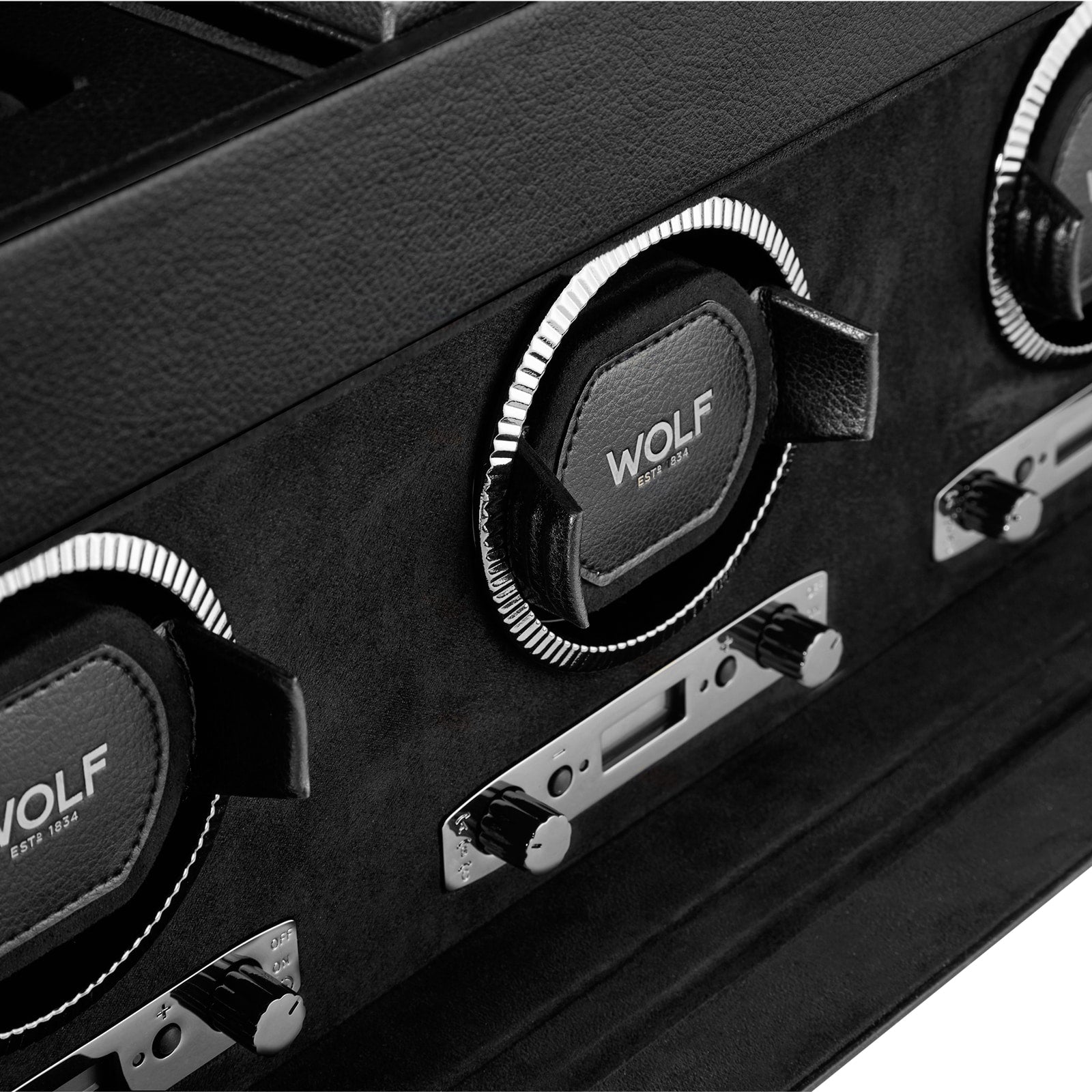 Close-up of a WOLF British Racing Triple Watch Winder with storage, featuring three watch holders and control knobs.