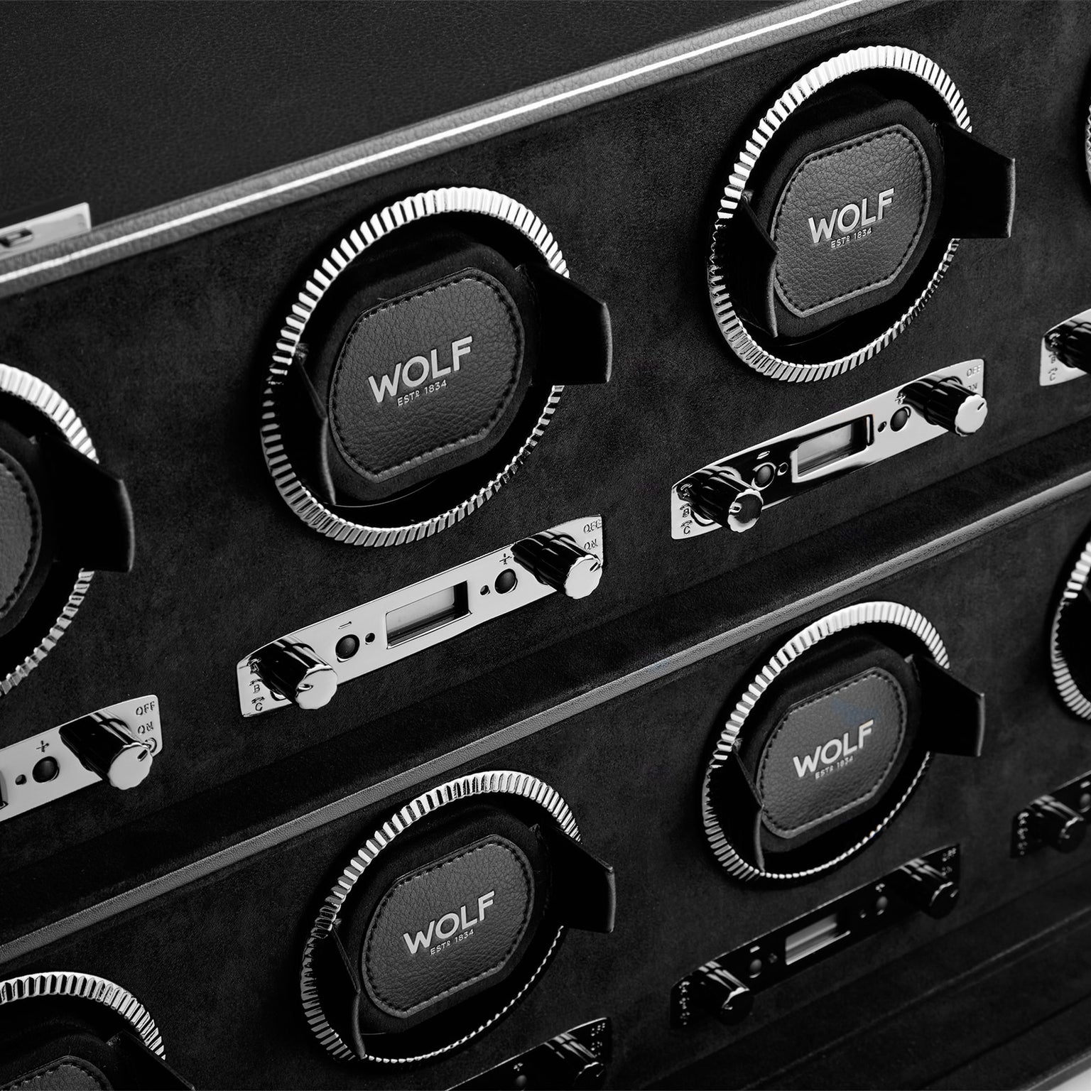 Close-up of multiple WOLF British Racing 8 Piece Watch Winders featuring control panels, black leather, and chrome detailing.