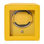 The WOLF Cub Single Watch Winder with Cover is yellow, has a glass front, and holds one watch inside.