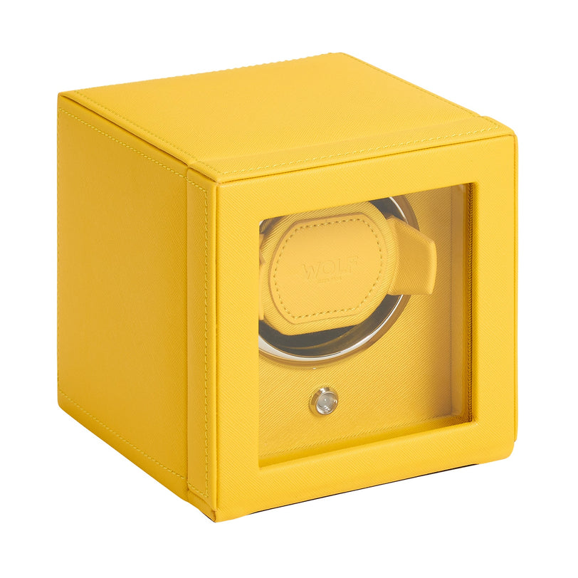 The WOLF Cub Single Watch Winder with Cover is a yellow box featuring a glass front and a circular watch holder inside.