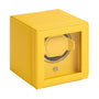 The WOLF Cub Single Watch Winder with Cover is a yellow box featuring a glass front and a circular watch holder inside.