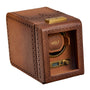 Brown leather watch winder with perforated brogue detailing, gold-tone hardware, and digital controls visible through front o
