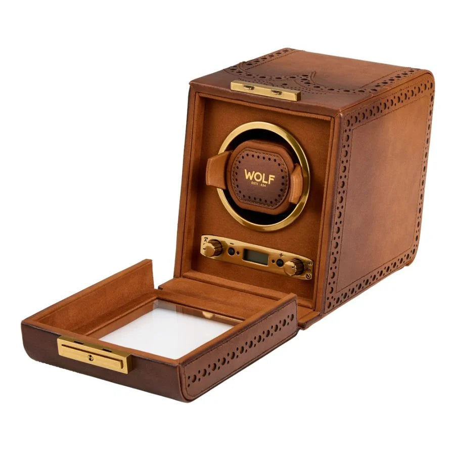 Brown leather watch winder with perforated detailing, gold-tone accents, rotating watch head, and open storage drawer.
