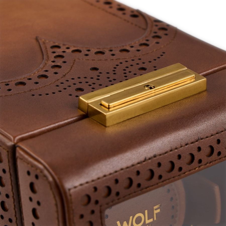 Brown leather watch winder with brogue perforations and gold-tone metal clasp on top.