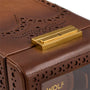 Brown leather watch winder with brogue perforations and gold-tone metal clasp on top.