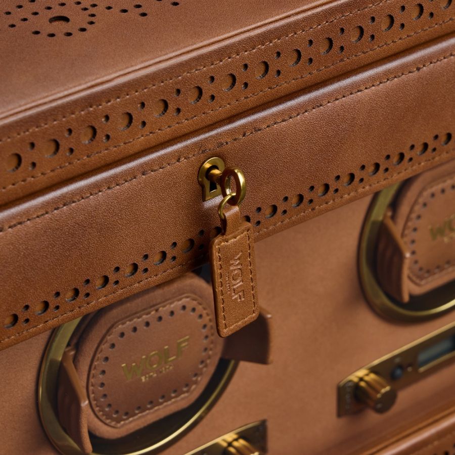 Tan leather brogue briefcase with perforated detailing, brass hardware, and multiple handles with storage compartments.