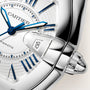 Cartier Roadster watch with white dial, blue hands, date window, and stainless steel bracelet.