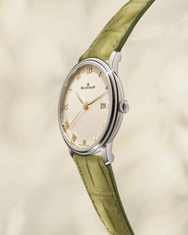 Blancpain Villeret watch with silver case, cream dial, gold Roman numerals, and green alligator leather strap.