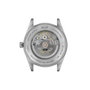 Stainless steel watch case back showing visible mechanical movement with gold gears and jeweled components.