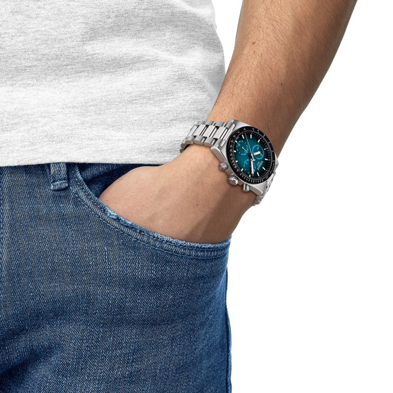 Person wearing a silver watch with a blue face on a white background